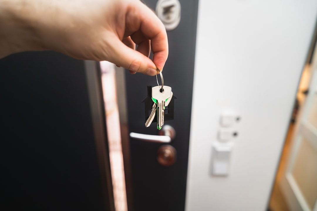 A set of house keys held at a front door